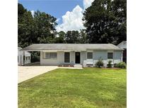 Charming home with a well-maintained front lawn and grey painted brick exterior and a carport at 2649 Santa Barbara Nw Dr, Atlanta, GA 30318