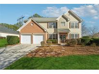 Brick and siding two-story house with a two-car garage and landscaped lawn at 724 Landsdowne Ln, Locust Grove, GA 30248
