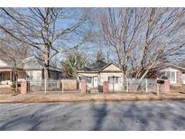 Tan house with white door, brick accents, and a black metal fence at 1415 Eric Se St, Atlanta, GA 30315