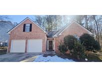 Brick front house with two-car garage and landscaping at 1432 Cutters Mill Dr, Lithonia, GA 30058