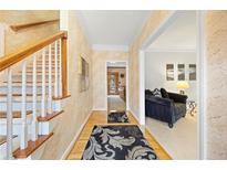 Bright foyer featuring hardwood floors, staircase, textured walls and an entryway to the living room at 5711 Brynwood Nw Cir, Acworth, GA 30101