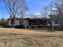 Ranch style home with red roof and mature trees at 3699 Irwin Bridge Nw Rd, Conyers, GA 30012