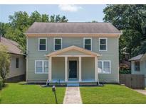 Two-story house with light green siding, a covered porch, and a well-maintained lawn at 1576 Mims Sw St, Atlanta, GA 30314