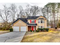 Two-story house with a two-car garage and landscaped lawn at 3447 Portsmouth Cir, Stonecrest, GA 30038