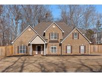 Brick two-story house with a large front yard and a wooden fence at 1105 Huntcrest Rdg, Mcdonough, GA 30252