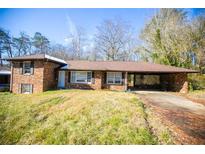 Brick ranch house with carport, situated on a spacious lot at 1351 Harbin Rd, Atlanta, GA 30311