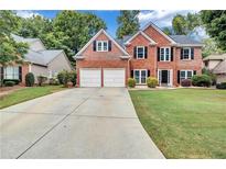 Brick house with 2-car garage and landscaped lawn at 1450 Grovehurst Dr, Marietta, GA 30062