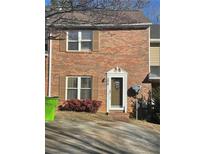 Brick townhouse with shutters, a door, and small front yard at 306 Flagstone Way # 306, Austell, GA 30168