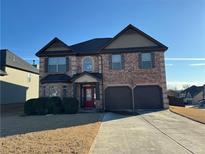 Two-story brick home with a three-car garage and landscaped yard at 845 Nevis Way, Mcdonough, GA 30253