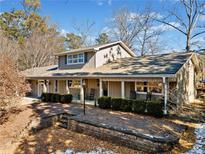 Gray house with wrap around porch and landscaped yard at 103 Cardinal Se Rd, White, GA 30184