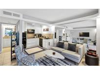 Open-concept living room and kitchen featuring sleek white cabinets and modern appliances at 141 Maison Nw Pl, Atlanta, GA 30327