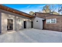 Contemporary home with gray and wood siding, and a spacious concrete patio at 4847 Lakewood Dr, Acworth, GA 30101