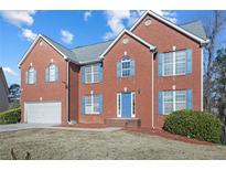 Brick house with blue door and shutters, two-car garage, and landscaped lawn at 4414 Parmalee Path, Conley, GA 30288