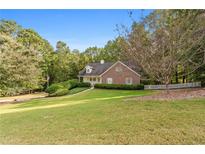 Brick house with landscaped lawn and driveway at 234 Hampton Shores Dr, Hampton, GA 30228