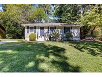 Ranch style home with a well-manicured lawn and mature trees at 1003 Springdale Dr, Marietta, GA 30062