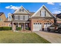 Two-story house with a brick facade, two-car garage, and landscaped lawn at 169 Blue Creek Ln, Loganville, GA 30052