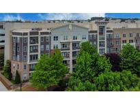 Modern apartment building with brick and stone accents, surrounded by lush green trees at 390 17Th Nw St # 4063, Atlanta, GA 30363