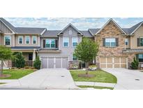 Two-story townhome with attractive landscaping and a two-car garage at 2475 Barley Crest Pass, Cumming, GA 30040