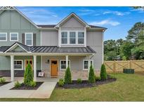 Two-story townhome with gray and green siding, a metal roof, and a front porch at 702 Fairgate Rd, Marietta, GA 30064