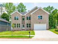 Two-story brick home with a white garage door and landscaped lawn at 5649 Eagles Watch, Douglasville, GA 30135