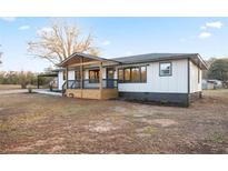 Ranch house with a modern farmhouse exterior, gray accents, and a wooden deck at 4605 Doss Cir, Powder Springs, GA 30127