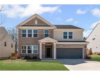 Charming two-story home with a brick and siding exterior, a well-manicured lawn, and an attached two-car garage at 236 Begonia Way, Mcdonough, GA 30253
