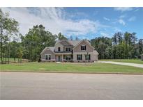 Two-story house with gray siding, brick accents, and a landscaped lawn at 21 Homesite Cooper E Cv, Fayetteville, GA 30215