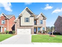 Brick two-story house with a large front yard and driveway at 2471 Arnold Palmer Way, Duluth, GA 30096