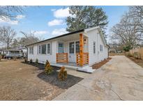 Charming renovated one-story home with a welcoming front porch and updated landscaping and a long driveway at 1900 Gober Se Ave, Smyrna, GA 30080
