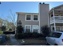 Two-story condo building with gray siding, balconies, and parking at 1345 Keys Crossing Ne Dr # 1345, Atlanta, GA 30319