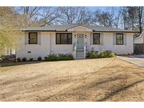 Charming ranch home with white brick exterior, landscaping, and a welcoming front porch at 2439 Woodridge Dr, Decatur, GA 30033