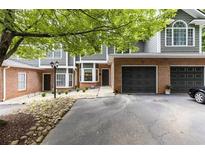 Brick and gray-sided townhouse with 2-car garage, landscaping, and a spacious driveway at 2680 Pine Tree Ne Rd # 2, Atlanta, GA 30324