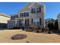 Charming two-story home featuring gray brick, complementary shutters, and a well-manicured front lawn at 522 Spring View Dr, Woodstock, GA 30188