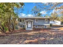 Gray house with stone accents, welcoming front entrance, and landscaping at 2234 Cherokee Valley Dr, Lithonia, GA 30058