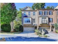 Attractive three-story townhome with two-car garage and manicured landscaping at 2790 Laurel Valley Trail, Buford, GA 30519