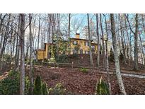 A charming stucco home nestled on a hillside, surrounded by lush woods at 1605 Brandon Hall Dr, Atlanta, GA 30350