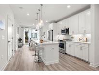 Bright, modern kitchen with white cabinets, stainless steel appliances, and hardwood floors at 396 Pratt Se Dr # 1932, Atlanta, GA 30315