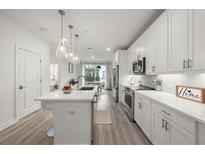 Bright, modern kitchen featuring white cabinetry, stainless steel appliances, and an island with pendant lighting at 396 Pratt Se Dr # 1932, Atlanta, GA 30315