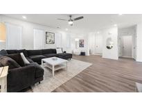 Spacious living room with modern ceiling fan, gray sectional, and bright windows at 396 Pratt Se Dr # 1932, Atlanta, GA 30315