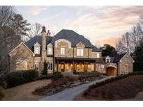 Stunning stone and brick home with a charming front porch and landscaped grounds at 4231 Whitestone Pl, Atlanta, GA 30327