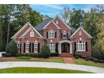 Brick house with black shutters, a large front yard, and a circular driveway at 2214 Taylor Grady Ter, Duluth, GA 30097