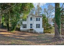 Two-story house with white siding, blue door, and a tree-lined yard at 1741 Charrington Way, Powder Springs, GA 30127