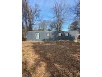 Grey block building with four small windows, situated on a lot with leaf-covered ground at 2025 Moody Sw Dr, Atlanta, GA 30315