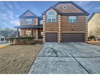 Brick two-story house with a three-car garage and landscaping at 8372 Members Dr, Jonesboro, GA 30236