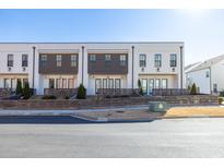 Three-unit townhome building with modern design, private patios, and wooden fences at 896 Farmstead Rd # 162, Suwanee, GA 30024