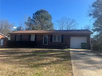 Brick ranch home with attached garage and driveway at 10650 Panhandle Rd, Hampton, GA 30228