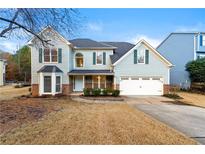 Two-story house with a two-car garage and landscaped lawn at 7124 Big Woods Dr, Woodstock, GA 30189