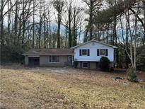 Ranch house with attached garage and mature trees at 905 Nw Magna Carta Dr, Atlanta, GA 30318