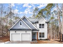 Two-story farmhouse with gray and white siding, two-car garage, and a light blue front door at 5086 Cumberland Ct, Villa Rica, GA 30180
