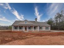 Charming single-story home featuring a welcoming front porch, gray siding and black shutters at 85 Woodfin Way, Social Circle, GA 30025